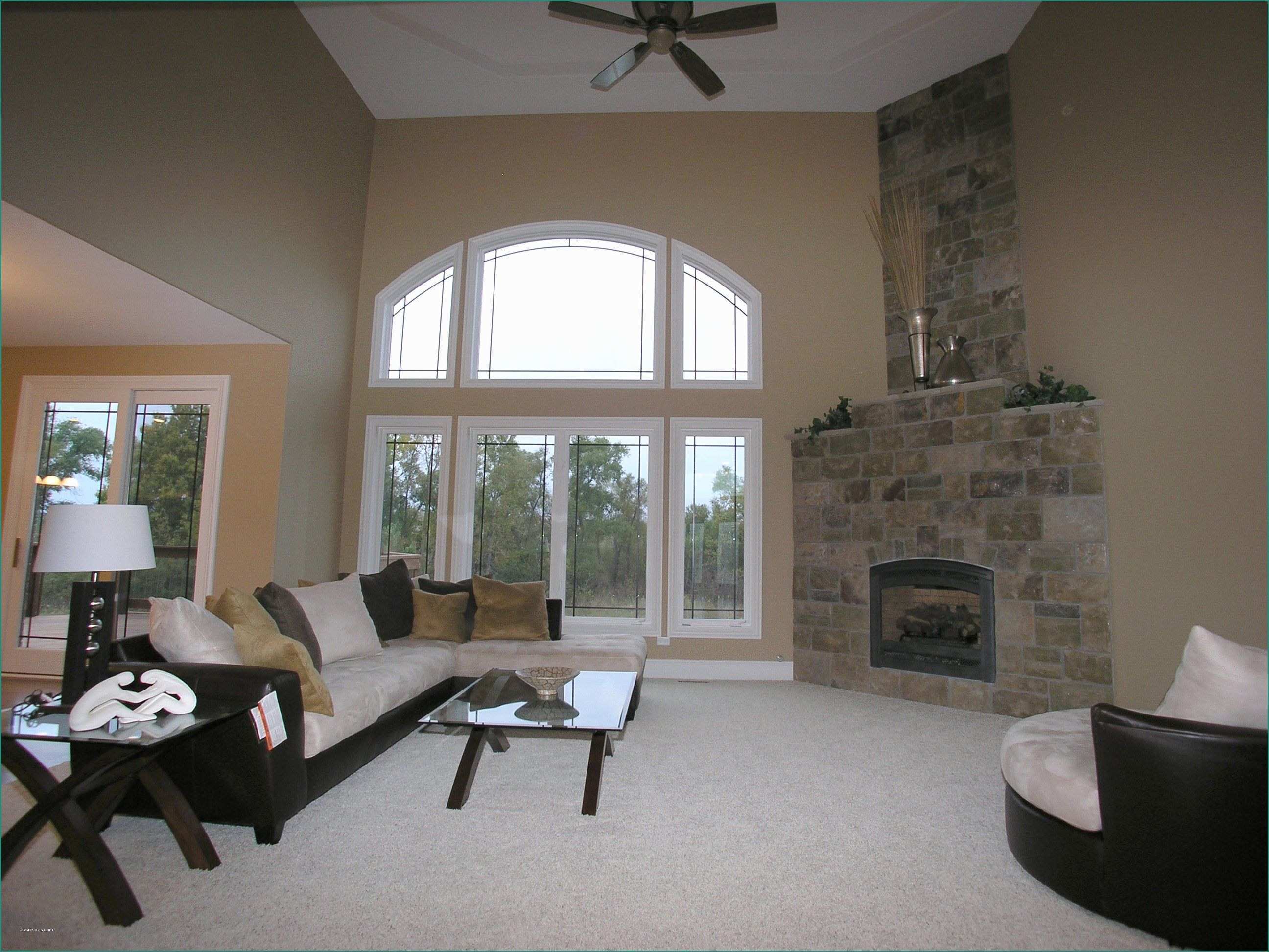 living room with high ceilings large windows and corner fireplace